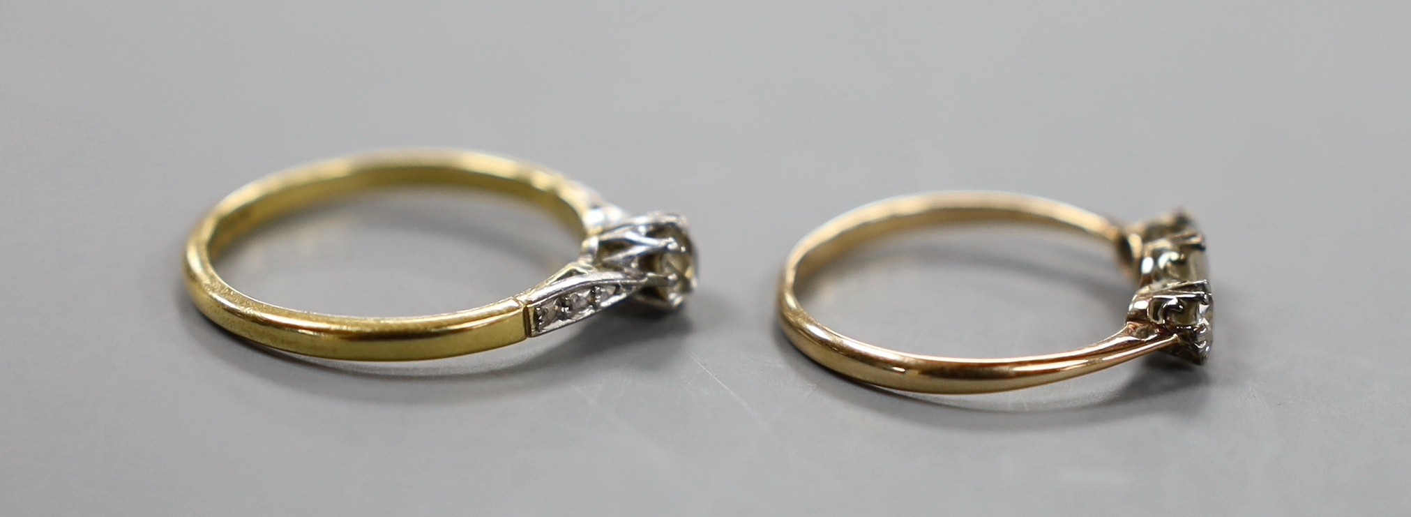 An 18ct and plat. single stone diamond ring, with diamond set shoulders, size O/P and a yellow metal and three stone diamond ring, size M, gross weight 3.8 grams.
